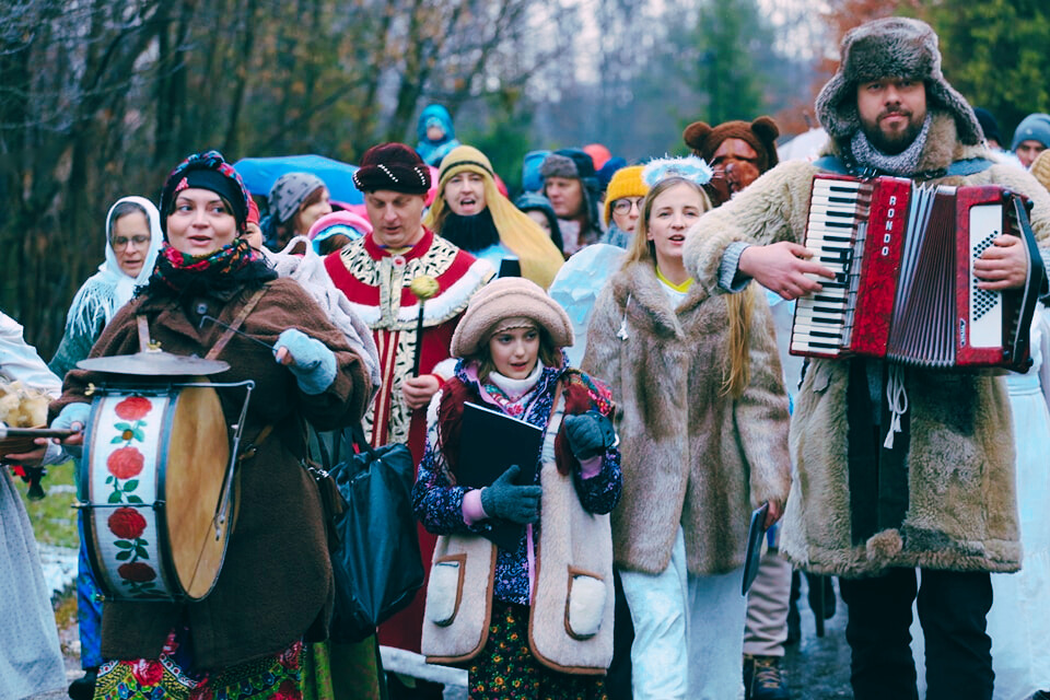 Kolędnicy w muzycznym korowodzie poprzebierani za pastuchów, królów, dziadów, niedźwiedzia, trzymający w rękach akordeon, bęben